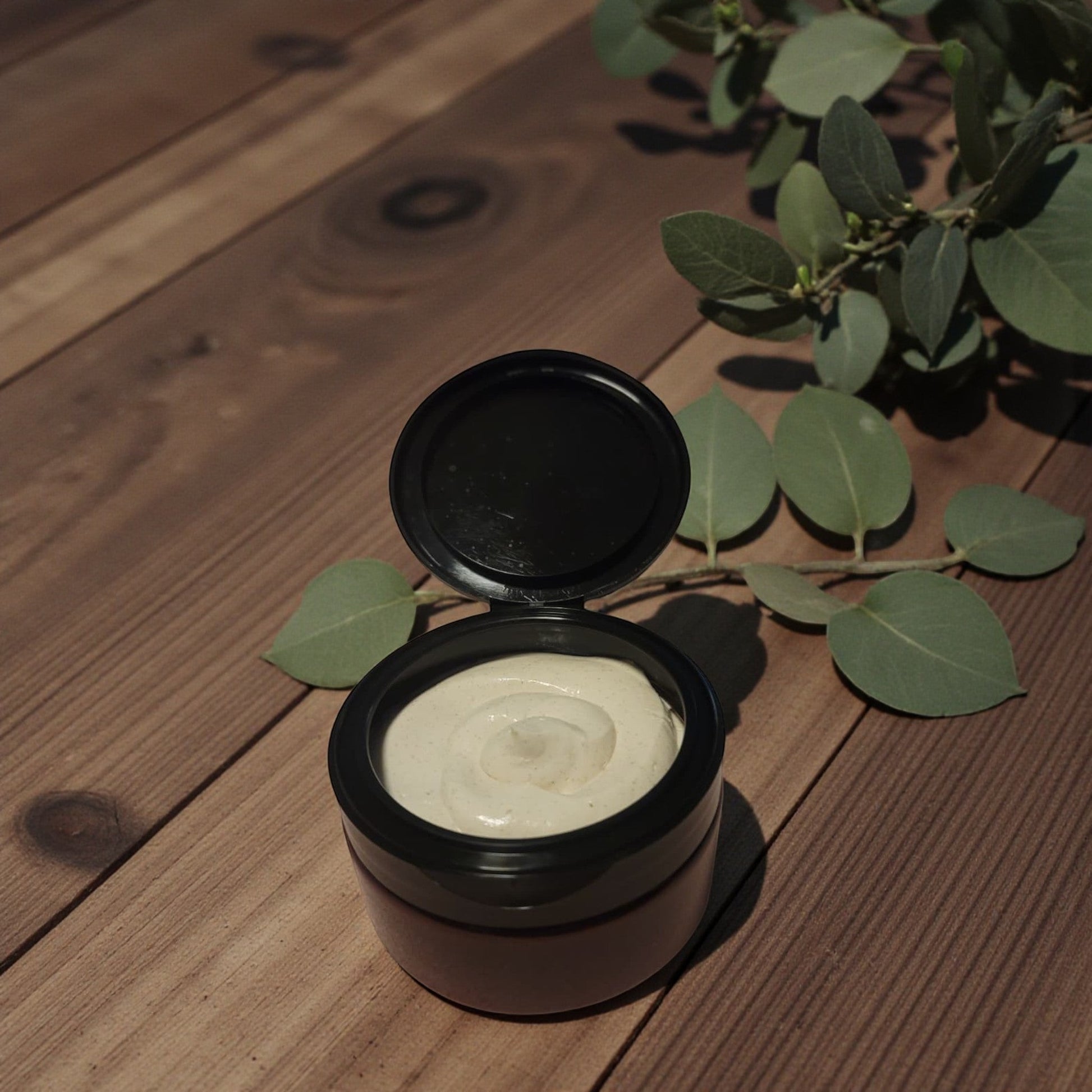 Haven Bliss Skincare Clove & Bay Body Cream in an open jar, showing its whipped, ivory texture. Natural lighting.