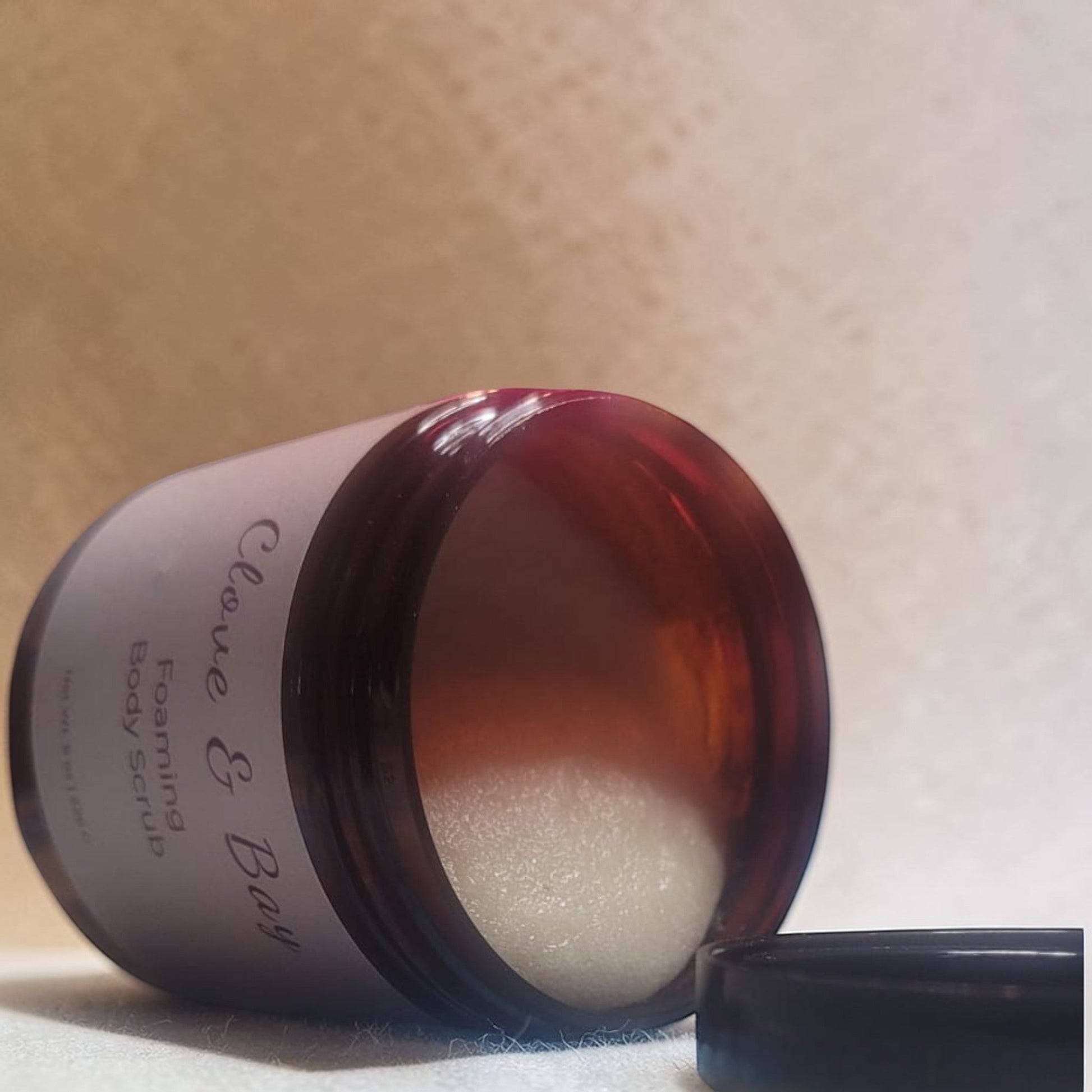 Haven Bliss Skincare Clove & Bay Foaming Body Scrub in amber jar with sugar scrub visible. Warm, comforting cleanse.